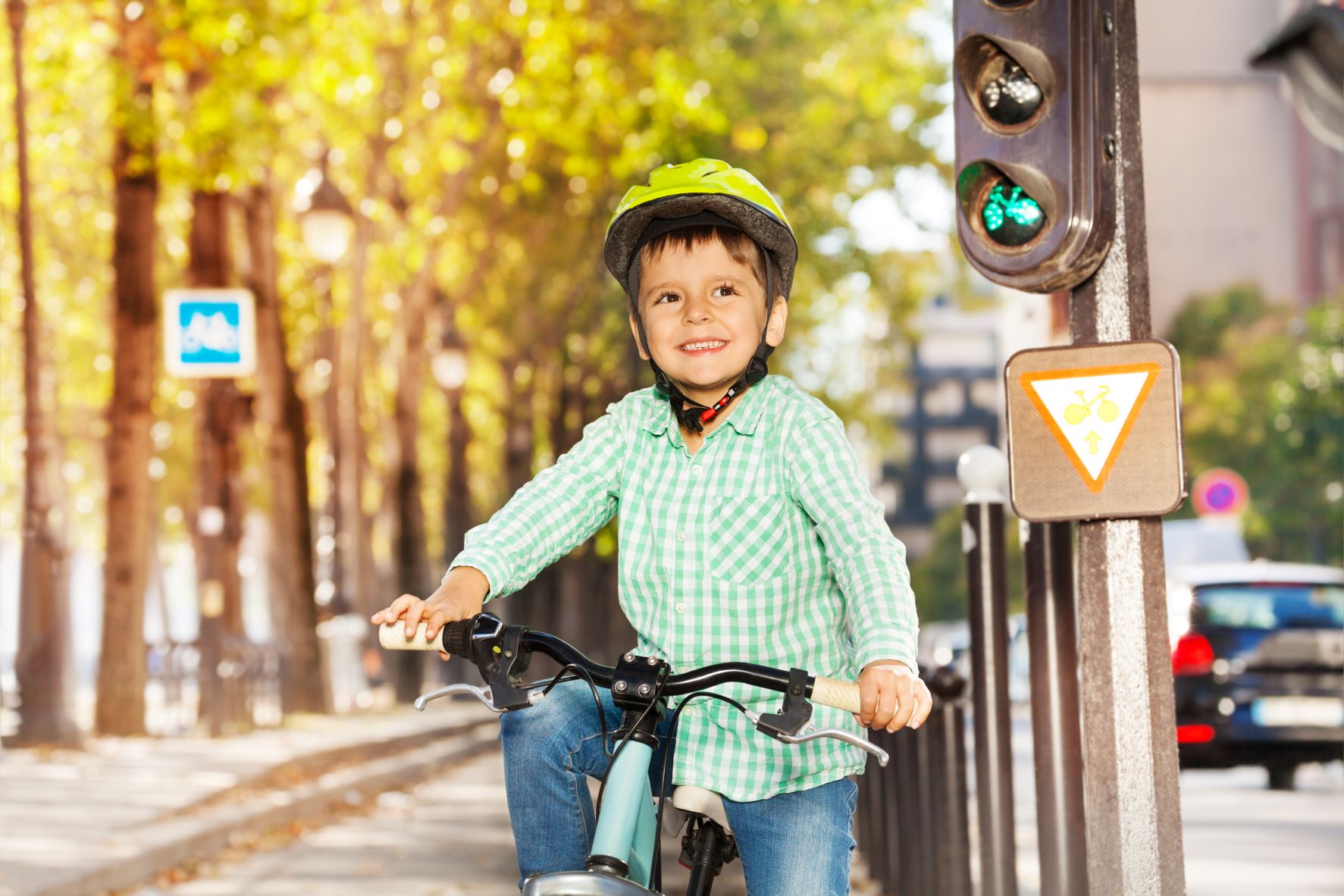 Pojke på cykel vid trafikljus