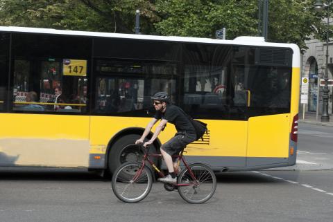 Cyklist och gul buss