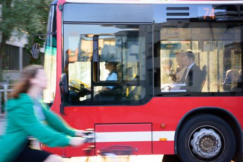 Bild på en buss och en kvinna som cyklar