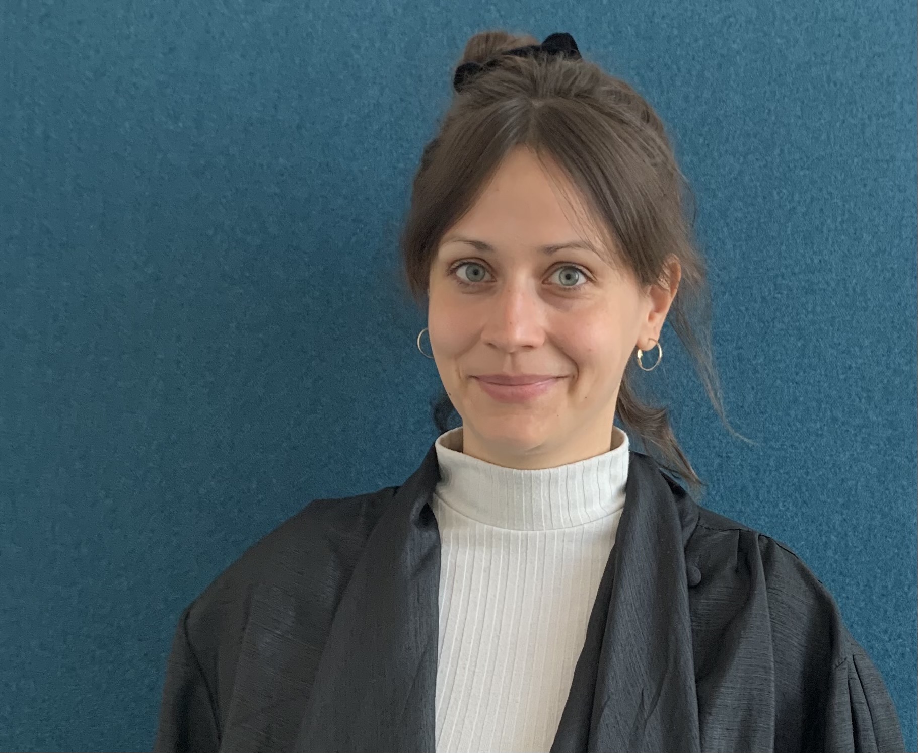 Porträttbild på Annika Otto mot en blå bakgrund.