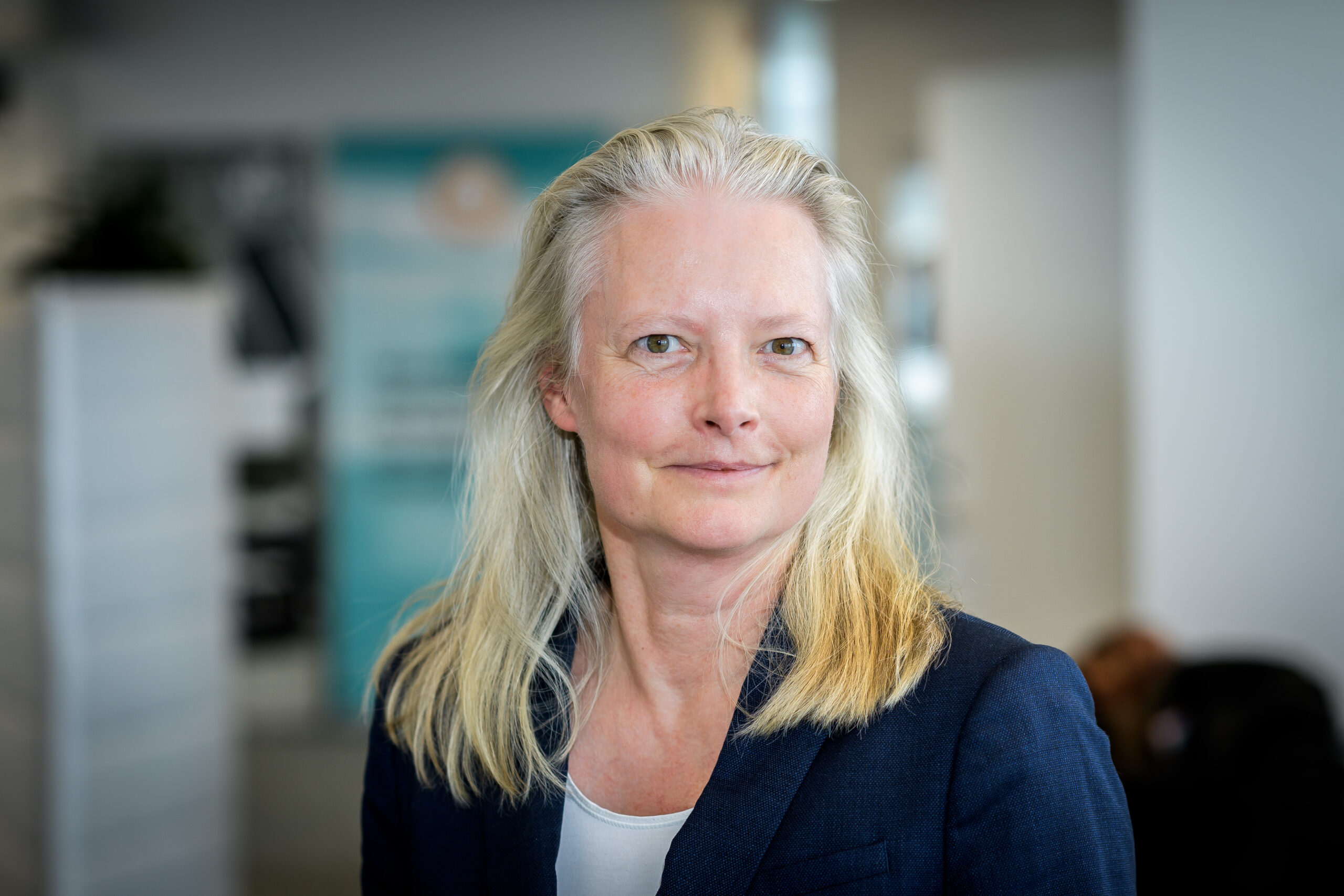 Porträttbild på Helene Lidestam mot en suddad bakgrund som visar en kontorsmiljö.
