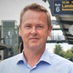 Porträttbild på Henrik Andersson stående på en perrong.