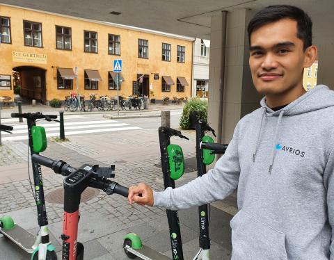 Ett foto på Phil Flores som håller i en elsparkcykel.
